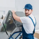 Handwerker transportieren Kühlschrank auf einer Sackkarre