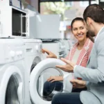 Junge Frau lässt sich beim Waschmaschinen Kauf beraten